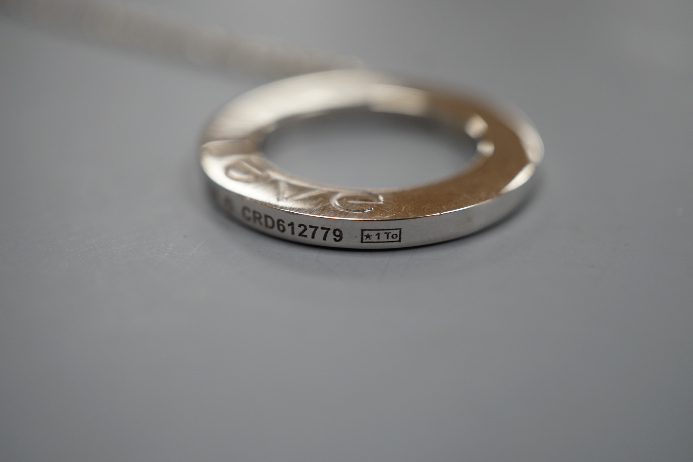 A modern Italian Cartier 750 white metal 'Love' circular pendant, 24mm, numbered CRD612779, on a 750 white metal fine link chain, 46cm, 10.8 grams.